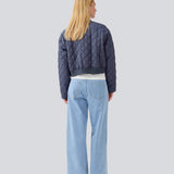 Let vatteret jakke i quiltet kvalitet med kort, ribbet krave og lynlås foran. HankMD jacket har en kort og løs facon. Produceret i genanvendt nylon. 