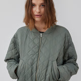 Let vatteret jakke i quiltet kvalitet med kort, ribbet krave og lynlås foran. HankMD jacket har en kort og løs facon. Produceret i genanvendt nylon. Modellen er 175 cm og har en størrelse S/36 på.