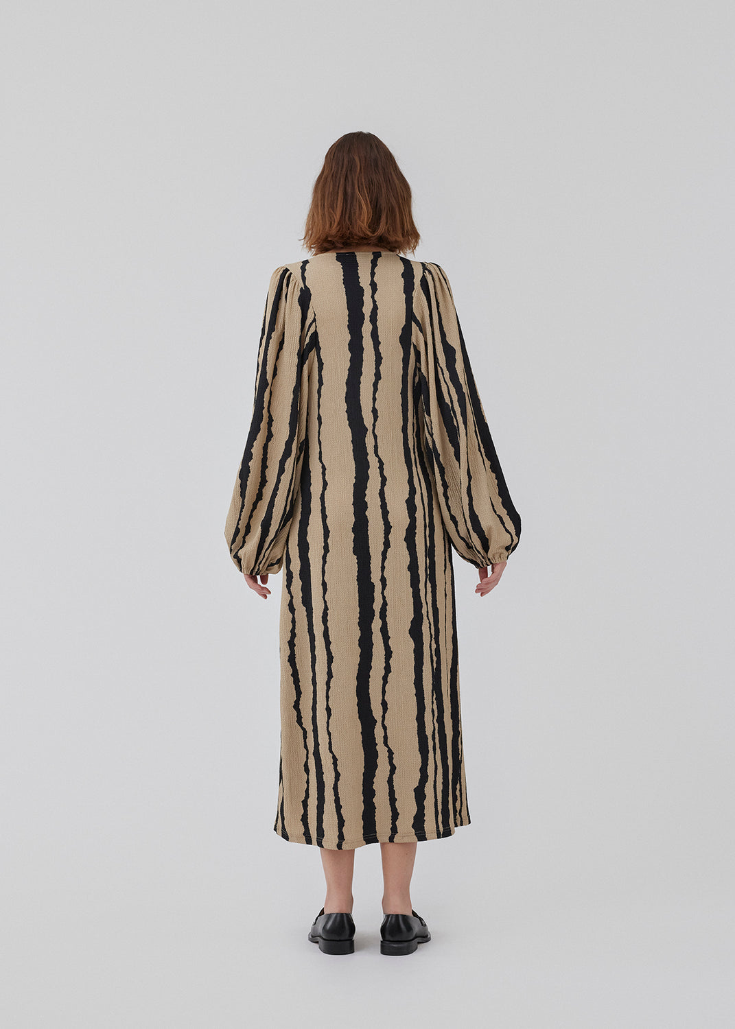 Printet midi kjole med v-udskæring i halsen og lange ballonærmer med elastik. HarlandMD print dress har en løs pasform. Modellen er 175 cm og har en størrelse S/36 på.