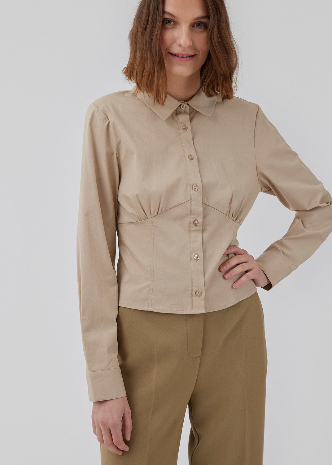 Figursyet skjorte i beige i vævet bomuldskvalitet med krave, knapper foran og lange ærmer med manchet. HarrisonMD shirt har indsnit og skæring under brystet for et korset-inspireret look. Modellen er 175 cm og har en størrelse S/36 på.