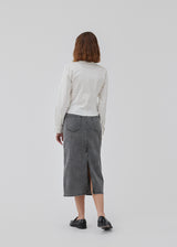 Midi nederdel i denim af bomuld. HarveyMD skirt har en høj talje, lynlåsgylp med knap og lige kant forneden med høj slids bagpå. Modellen er 175 cm og har en størrelse S/36 på.
