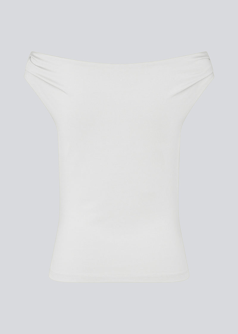 Off-shoulder top i hvid i et elastisk materiale. HimaMD off-shoulder top har en tætsiddende pasform og er let cropped.