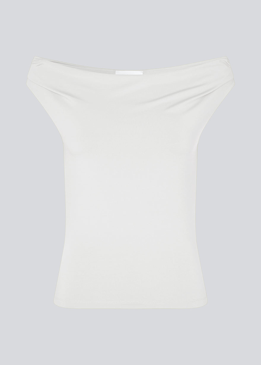 Off-shoulder top i hvid i et elastisk materiale. HimaMD off-shoulder top har en tætsiddende pasform og er let cropped.
