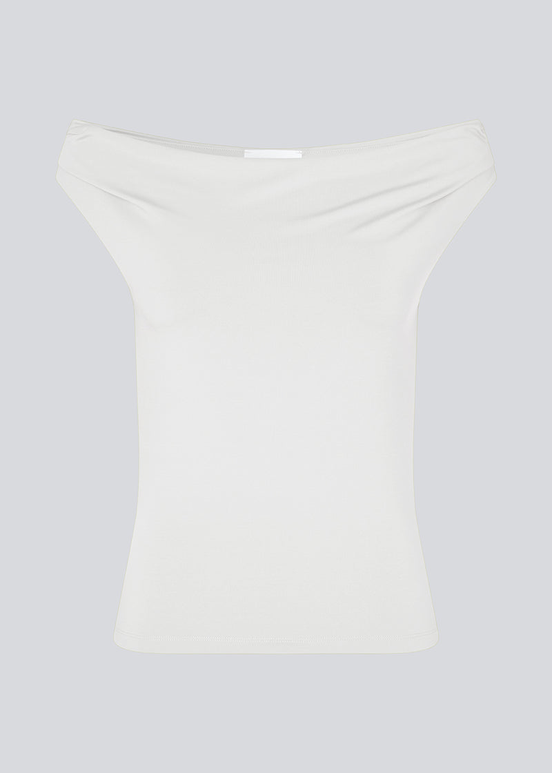 Off-shoulder top i hvid i et elastisk materiale. HimaMD off-shoulder top har en tætsiddende pasform og er let cropped.