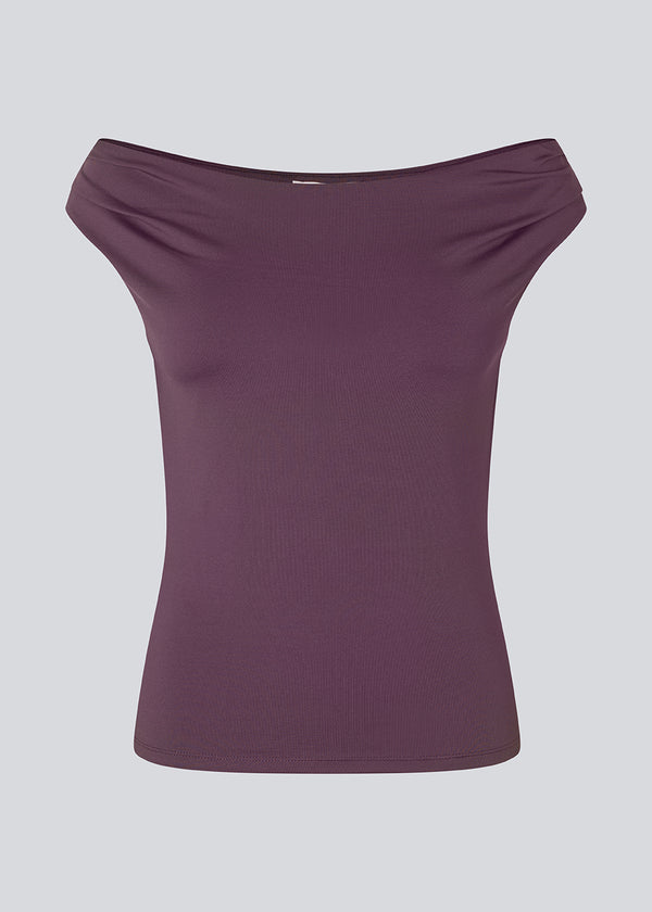 Lilla off-shoulder top i et elastisk materiale. HimaMD off-shoulder top har en tætsiddende pasform og er let cropped.&nbsp;