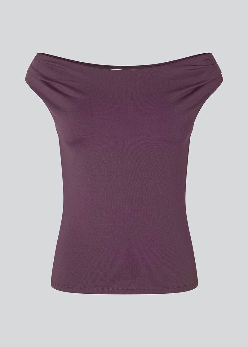 Lilla off-shoulder top i et elastisk materiale. HimaMD off-shoulder top har en tætsiddende pasform og er let cropped.&nbsp;