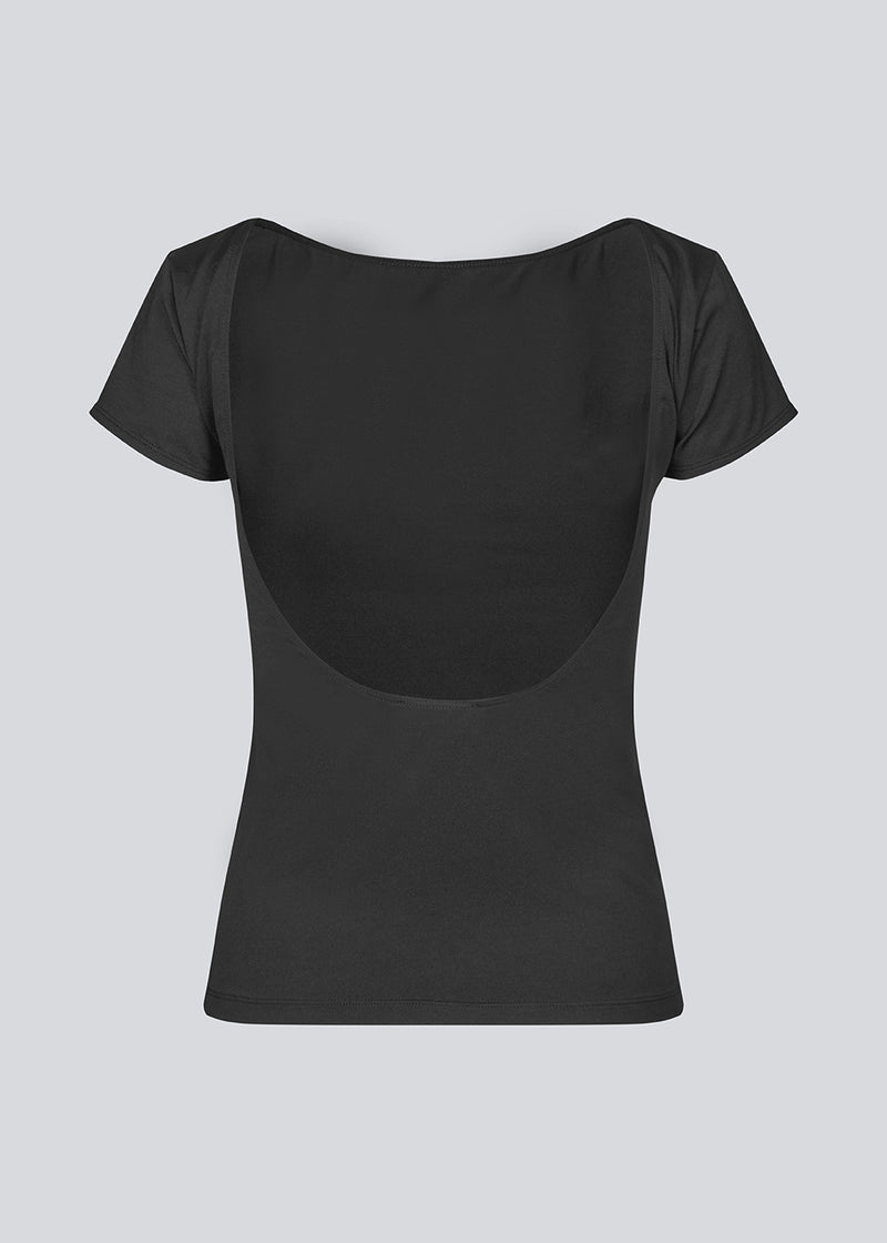 Sort t-shirt med bar ryg og korte ærmer i et elastisk materiale. HimaMD t-shirt har en tætsiddende silhuet med en dyb rygudskæring. Modellen er 175 cm og har en størrelse S/36 på.
