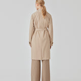 Trenchcoat jakke i beige med i et klassisk udtryk bred krave, bælte i livet og knaplukning. Hiro jacket er perfekt som overgangsjakke fra vinter til forår. Jakken har en rummelig pasform. Vi anbefaler at gå en størrelse ned. Modellen er 174 cm og har en størrelse S/36 på.