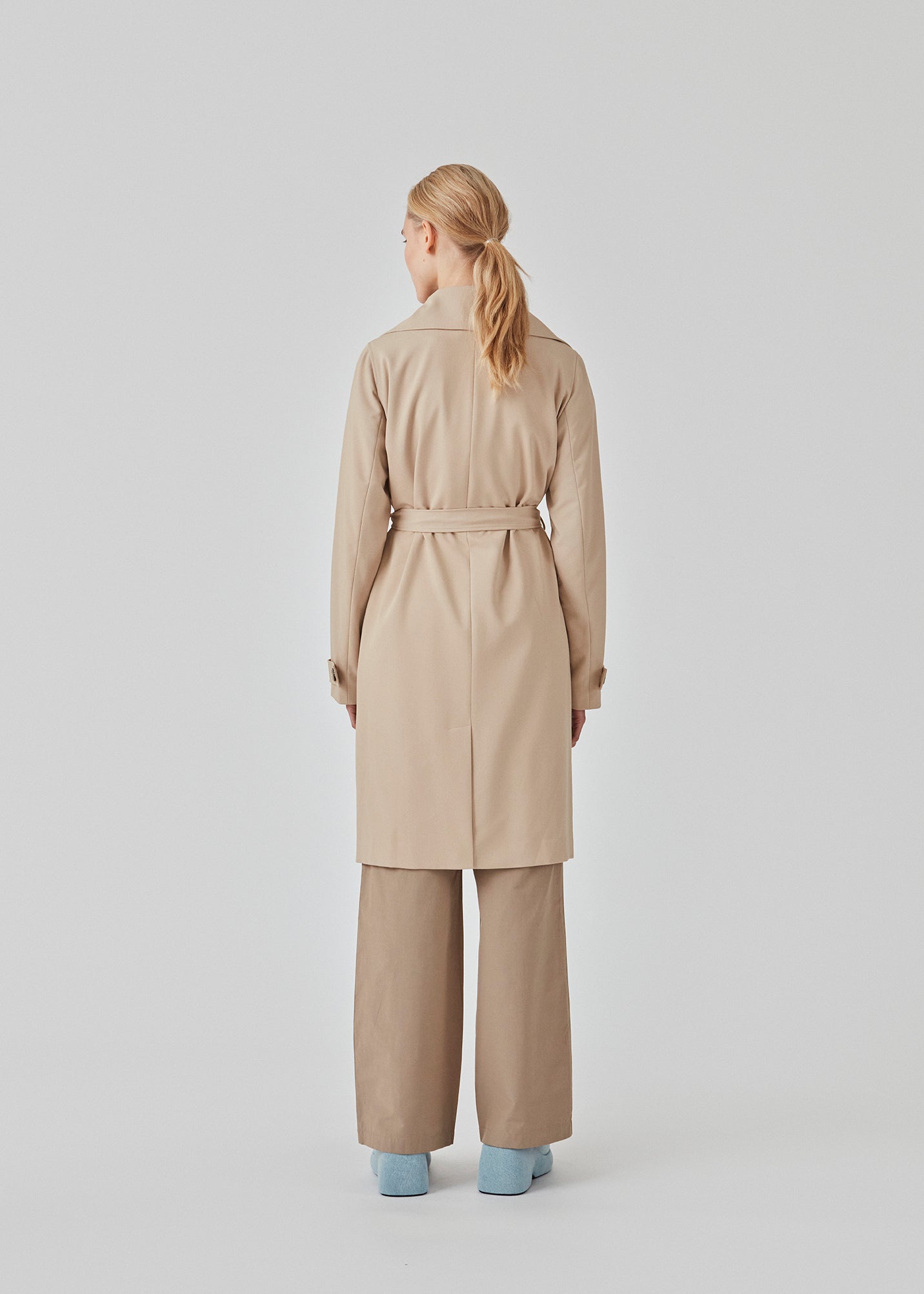 Trenchcoat jakke i beige med i et klassisk udtryk bred krave, bælte i livet og knaplukning. Hiro jacket er perfekt som overgangsjakke fra vinter til forår. Jakken har en rummelig pasform. Vi anbefaler at gå en størrelse ned. Modellen er 174 cm og har en størrelse S/36 på.