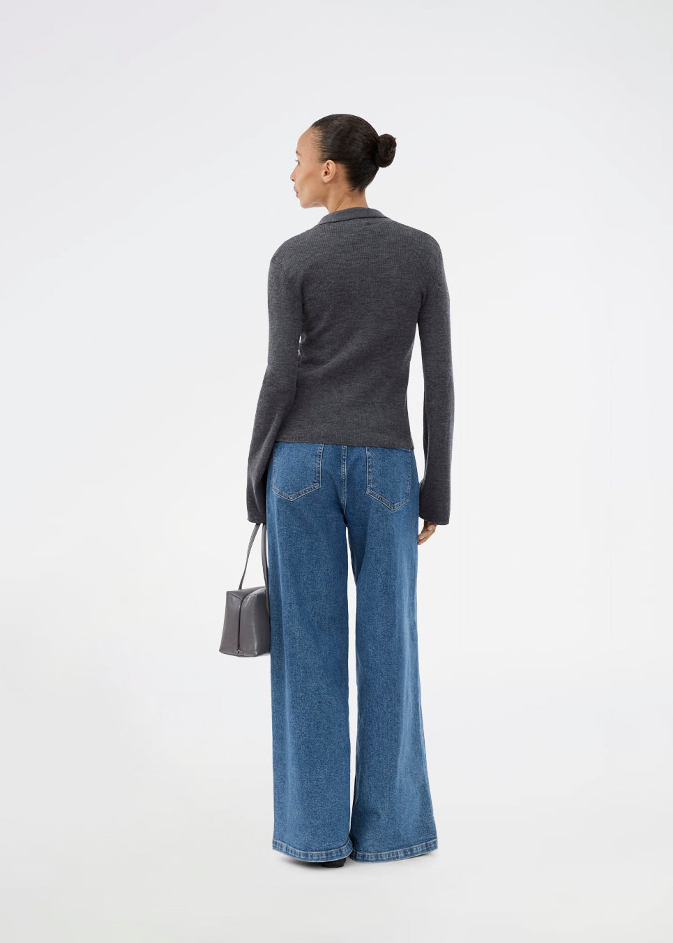 Mørkegrå tætsiddende cardigan i blød ribstrik af uld. HirokiMD cardigan har krave, knapper foran og lange ærmer med slids og knapper. Modellen er 175 cm og har en størrelse S/36 på.