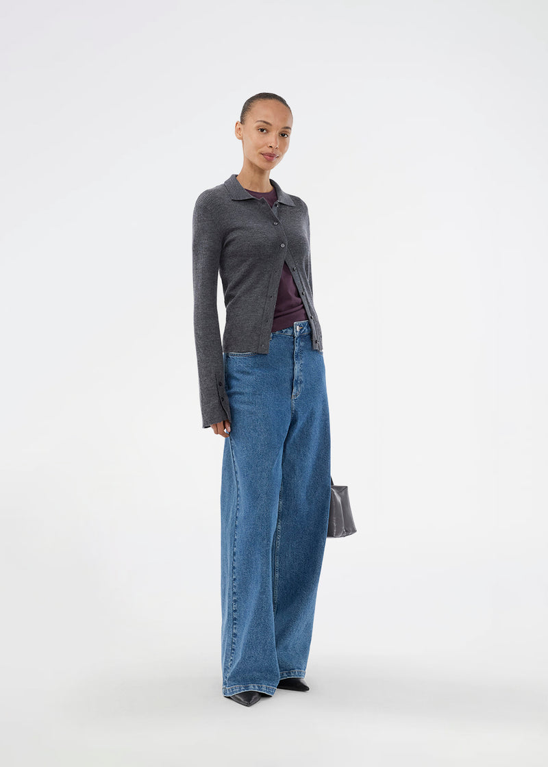 Mørkegrå tætsiddende cardigan i blød ribstrik af uld. HirokiMD cardigan har krave, knapper foran og lange ærmer med slids og knapper. Modellen er 175 cm og har en størrelse S/36 på.