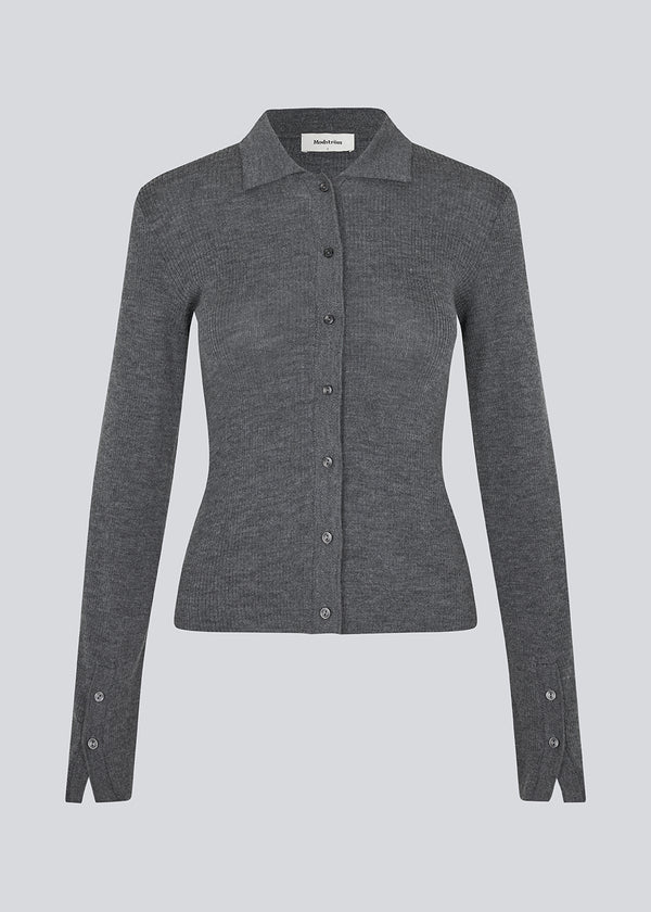 Mørkegrå tætsiddende cardigan i blød ribstrik af uld. HirokiMD cardigan har krave, knapper foran og lange ærmer med slids og knapper. Modellen er 175 cm og har en størrelse S/36 på.