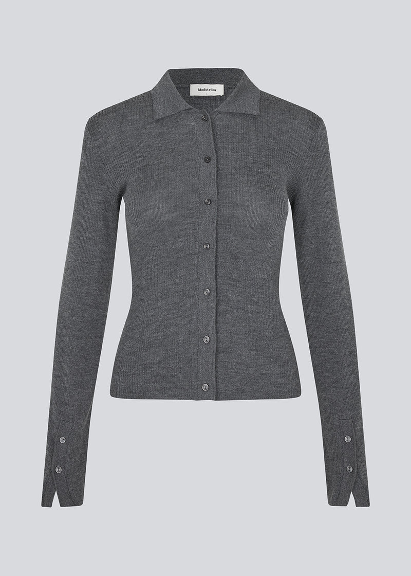 Mørkegrå tætsiddende cardigan i blød ribstrik af uld. HirokiMD cardigan har krave, knapper foran og lange ærmer med slids og knapper. Modellen er 175 cm og har en størrelse S/36 på.