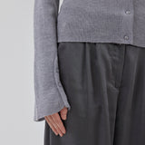 Tætsiddende cardigan i grå i blød ribstrik af uld. HirokiMD cardigan har krave, knapper foran og lange ærmer med slids og knapper. Modellen er 175 cm og har en størrelse S/36 på.