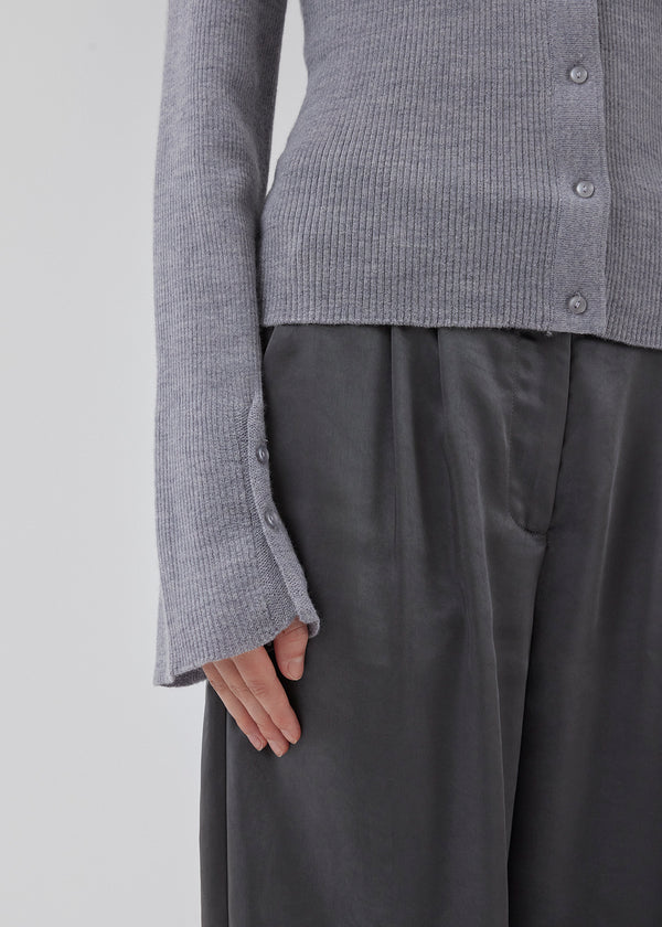 Tætsiddende cardigan i grå i blød ribstrik af uld. HirokiMD cardigan har krave, knapper foran og lange ærmer med slids og knapper. Modellen er 175 cm og har en størrelse S/36 på.