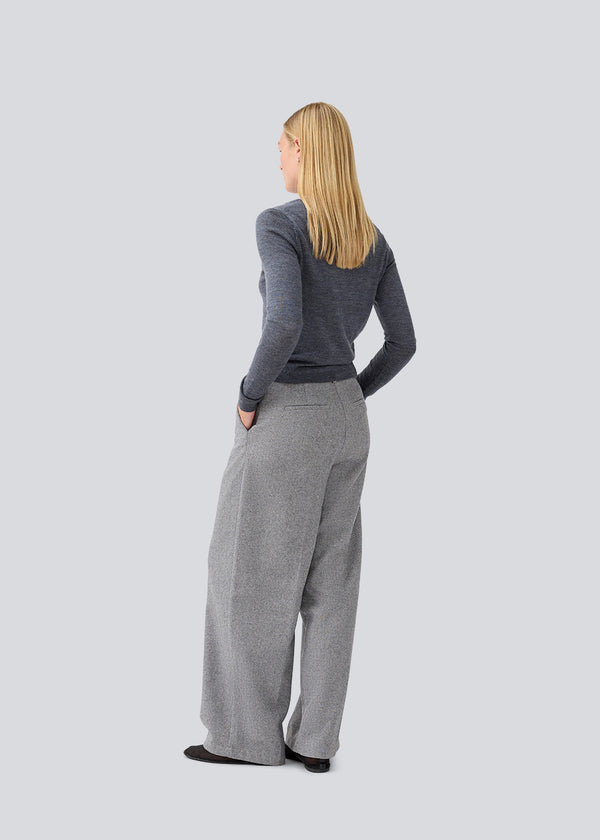 Tætsiddende mørkegrå cardigan i blød strik. HirokiMD short cardigan har en rund hals og knappelukning fortil. Modellen er 177 cm og har en størrelse S/36 på.