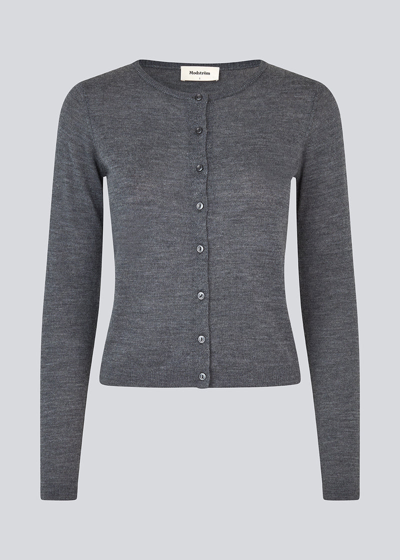 Tætsiddende mørkegrå cardigan i blød strik. HirokiMD short cardigan har en rund hals og knappelukning fortil. Modellen er 177 cm og har en størrelse S/36 på.