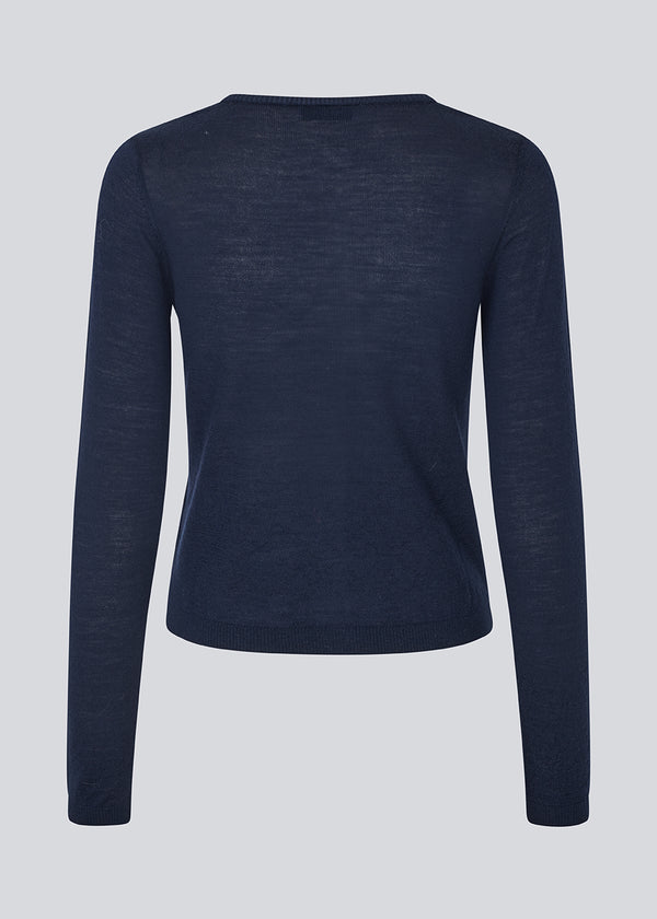 Tætsiddende cardigan i blød strik. HirokiMD short cardigan har en rund hals og knappelukning fortil. 