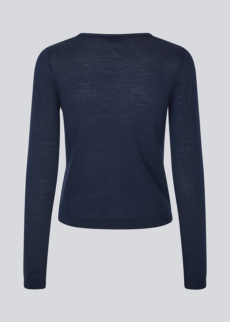 Tætsiddende cardigan i blød strik. HirokiMD short cardigan har en rund hals og knappelukning fortil. 