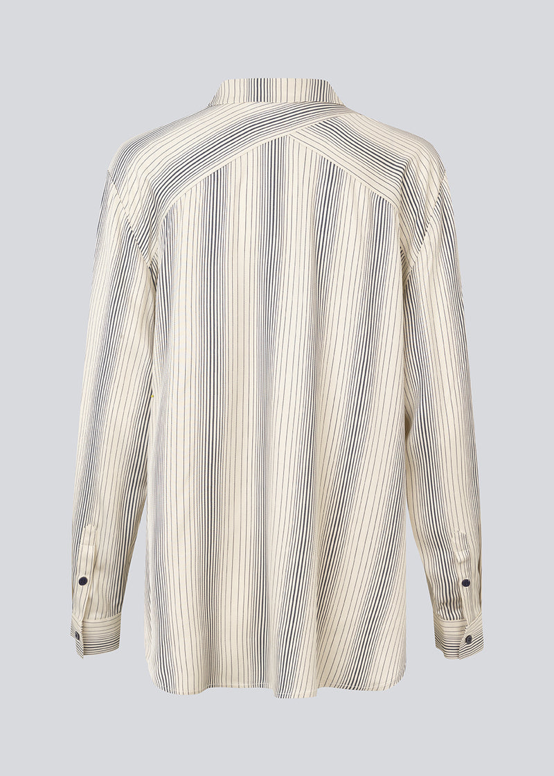 Oversize skjorte med krave og knaplukning fortil. HissaMD print shirt har brede ærmer med manchet og detaljeret bærestykke bagpå. 