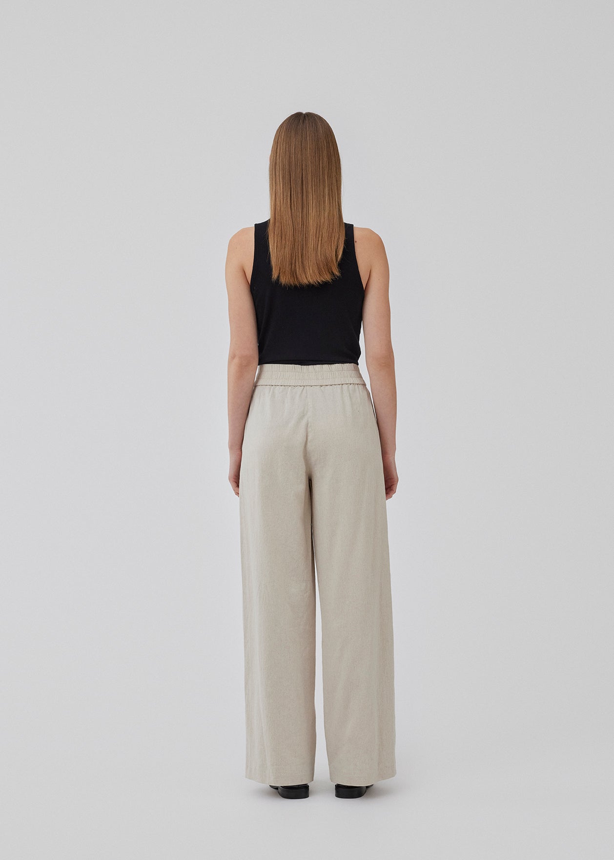 Bukser i beige med afslappet udtryk og pasform i kvalitet af bomuld og hør. HonorMD pants har løse ben og mellemhøj talje med bred elastikkant. Modellen er 175 cm og har en størrelse S/36 på.