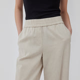 Bukser i beige med afslappet udtryk og pasform i kvalitet af bomuld og hør. HonorMD pants har løse ben og mellemhøj talje med bred elastikkant. Modellen er 175 cm og har en størrelse S/36 på.