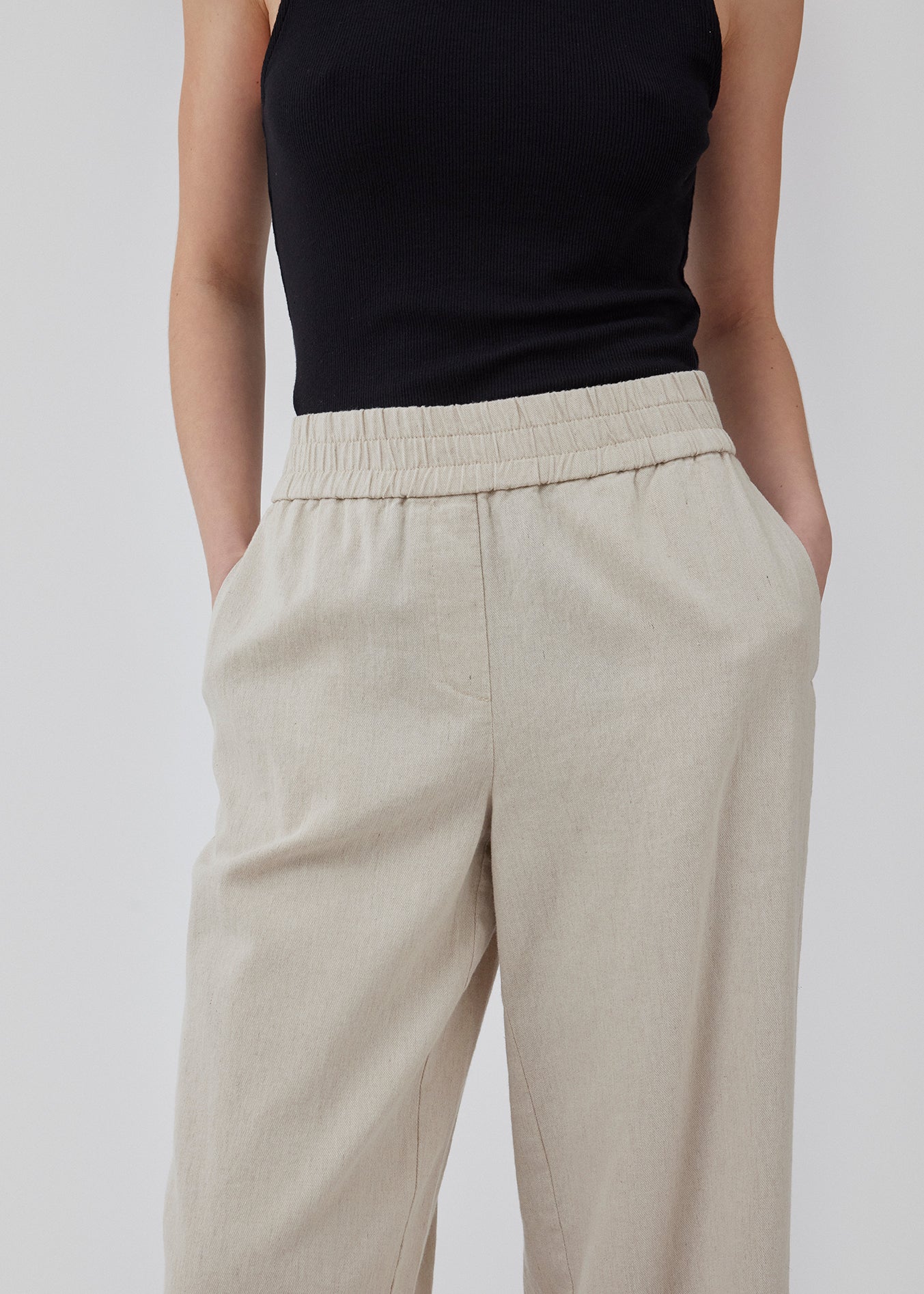 Bukser i beige med afslappet udtryk og pasform i kvalitet af bomuld og hør. HonorMD pants har løse ben og mellemhøj talje med bred elastikkant. Modellen er 175 cm og har en størrelse S/36 på.