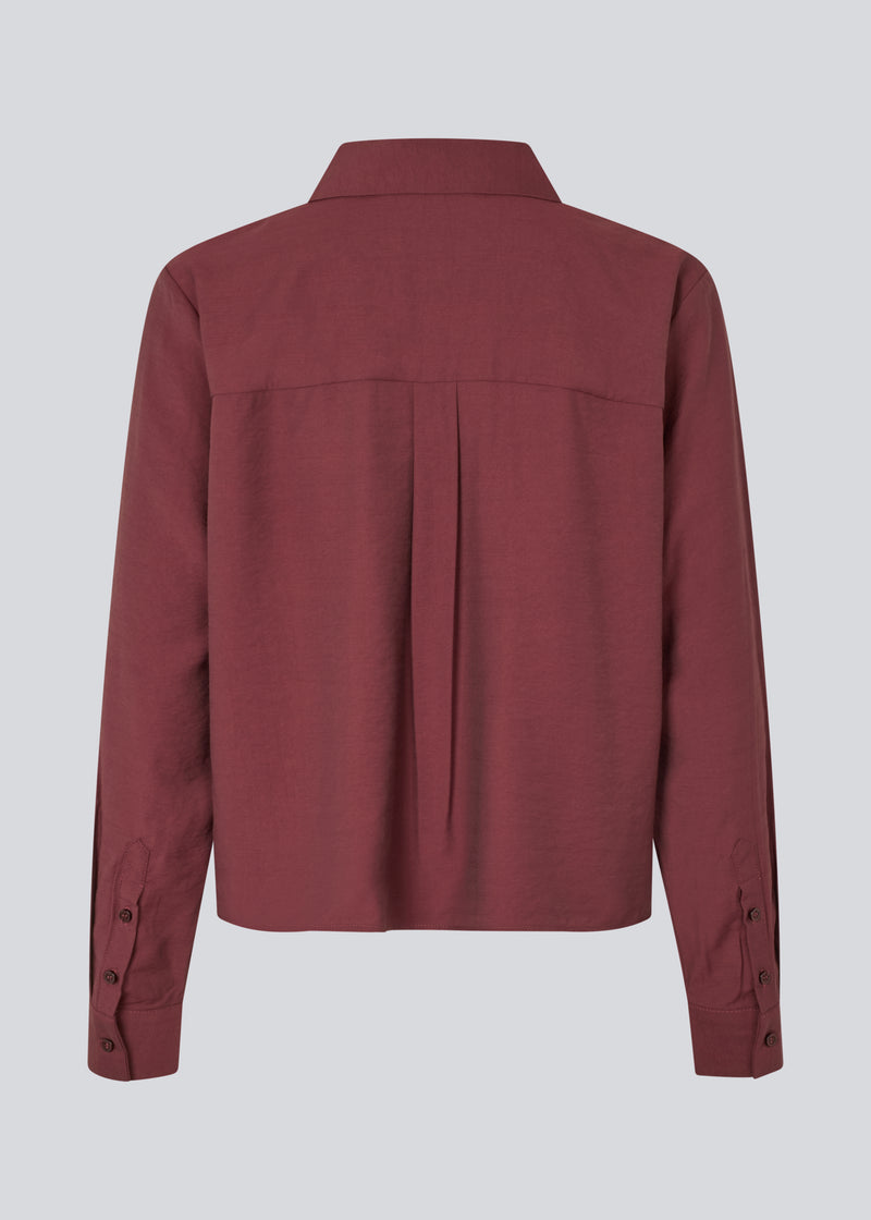Rød skjorte i en let EcoVero viskose med løs pasform. HudgesMD shirt har krave og knaplukning fortil og lange ærmer med manchet. Modellen er 175 cm og har en størrelse S/36 på.