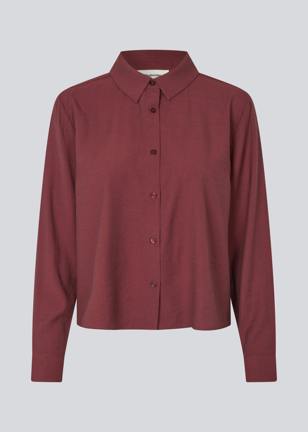 Rød skjorte i en let EcoVero viskose med løs pasform. HudgesMD shirt har krave og knaplukning fortil og lange ærmer med manchet. Modellen er 175 cm og har en størrelse S/36 på.