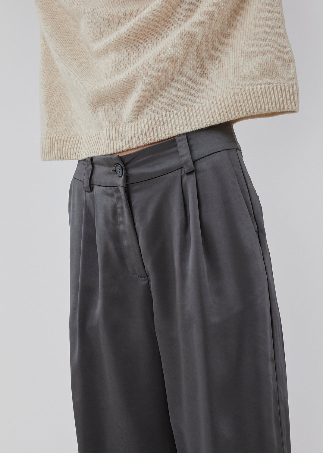 Bukser i satin med lynlåsgylp og knap i taljen. HudsonMD pants har en almindelig talje med læg, skrå sidelommer og dekorative paspolerede baglommer. Modellen er 175 cm og har en størrelse S/36 på.