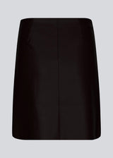 Kort, asymmetrisk slå om-nederdel i sort i imiteret læder. HuxleyMD skirt har en skjult lynlås i den ene side. Modellen er 175 cm og har en størrelse S/36 på.