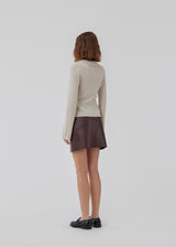 Kort, asymmetrisk slå om-nederdel i bordeaux i imiteret læder. HuxleyMD skirt har en skjult lynlås i den ene side. Modellen er 175 cm og har en størrelse S/36 på.