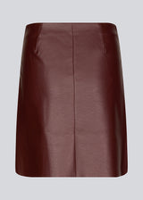 Kort, asymmetrisk slå om-nederdel i bordeaux i imiteret læder. HuxleyMD skirt har en skjult lynlås i den ene side. Modellen er 175 cm og har en størrelse S/36 på.