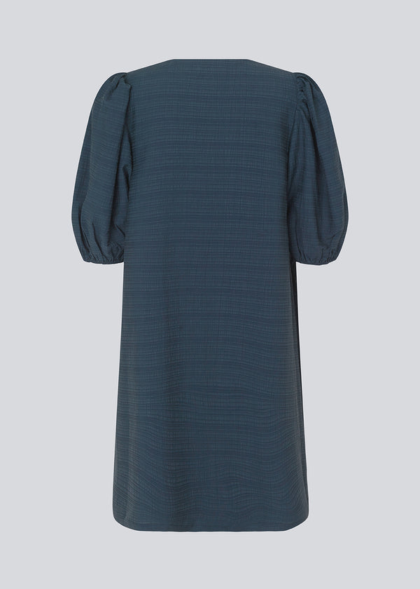 Midi kjole i mørkeblå med en løs pasform og V-halsudskæring. IbiMD flare dress har pufærmer i 3/4 ærmelænge med elastik.