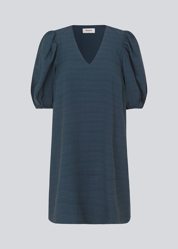 Midi kjole i mørkeblå med en løs pasform og V-halsudskæring. IbiMD flare dress har pufærmer i 3/4 ærmelænge med elastik.