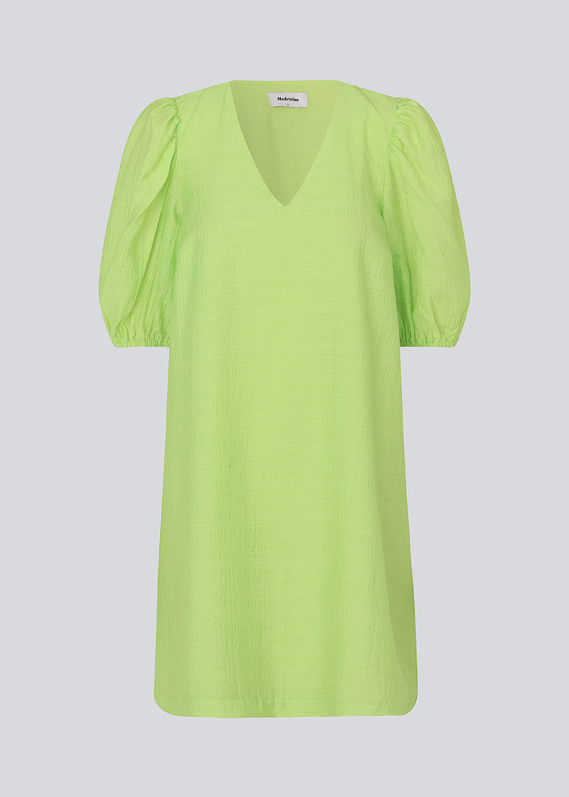 Midi kjole i lime grøn med en løs pasform og V-halsudskæring. IbiMD flare dress har pufærmer i 3/4 ærmelænge med elastik.