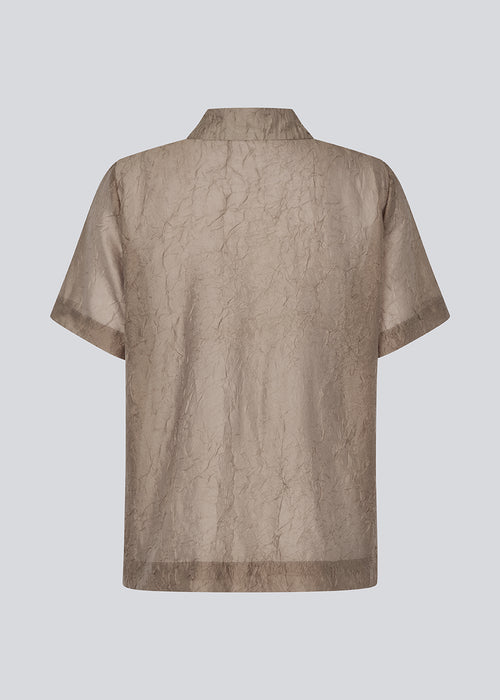 Løs skjorte i brun i let transparant og struktureret materiale. IdrisMD shirts har korte ærmer og en slids i siderne.