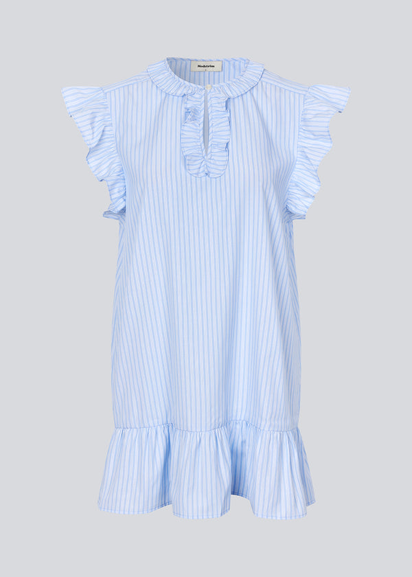 Kort, ærmeløs kjole med flæsedetaljer. InaraMD dress har et hul fortil, som lukkes med en knap og en dekorativ flæsekant. Modellen er 177 cm og har en størrelse S/36 på.