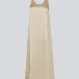 Lang kjole i beige i satin med A-formet silhuet. IolaMD dress har en dyb rygudskæring og brede stropper. Modellen er 177 cm og har en str S/36 på.