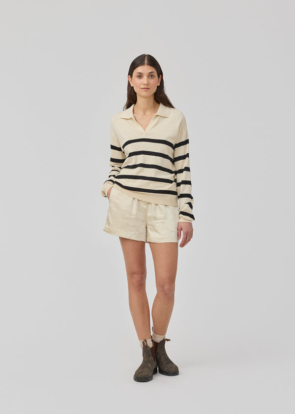 Løse beige shorts i satin med elastik i taljen. IolaMD shorts har en mellemhøj taljeog sidelommer. Modellen er 177 cm og har en størrelse S/36 på.