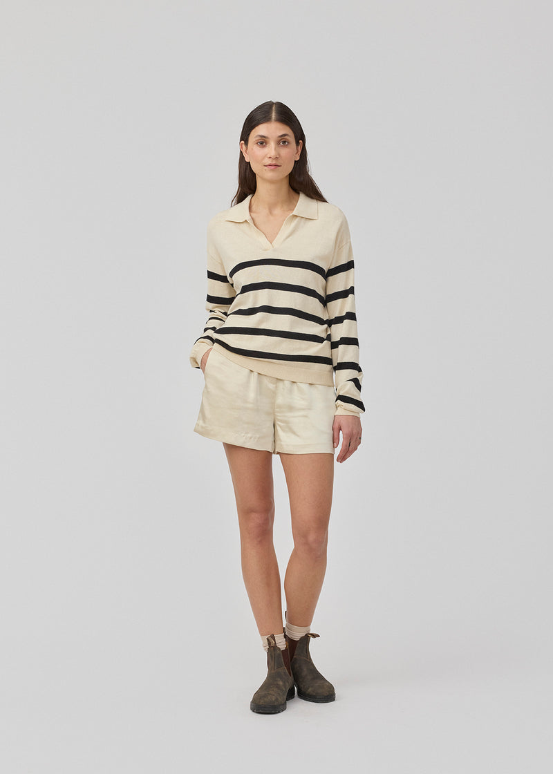 Løse beige shorts i satin med elastik i taljen. IolaMD shorts har en mellemhøj taljeog sidelommer. Modellen er 177 cm og har en størrelse S/36 på.