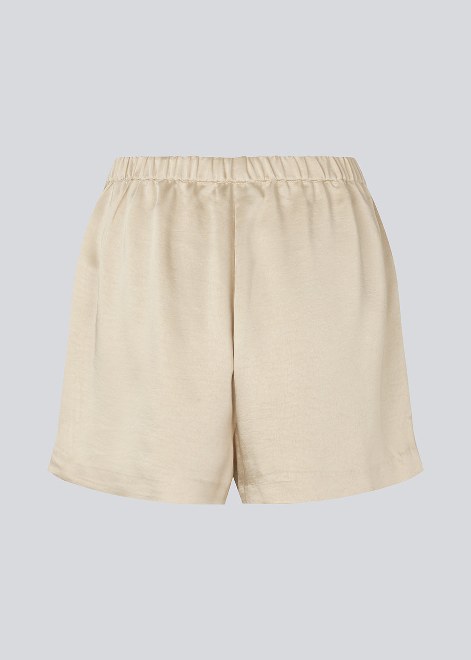 Løse beige shorts i satin med elastik i taljen. IolaMD shorts har en mellemhøj taljeog sidelommer. Modellen er 177 cm og har en størrelse S/36 på.