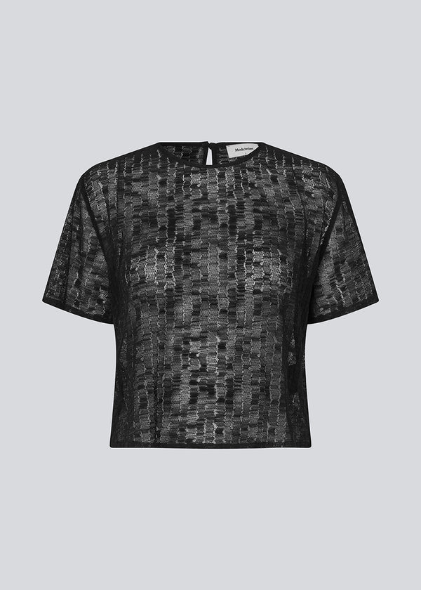 Løs t-shirt I et let transparant materiale. IrmaMD top har en åbning i rykken som lukkes med en knap.