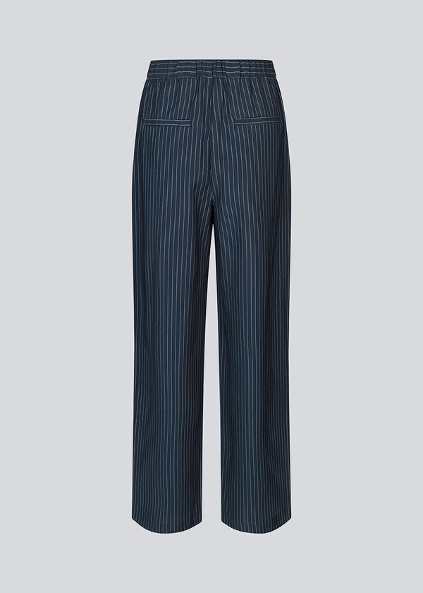 Habitbukser i mørkeblå med mellemhøj talje, læg og lange, vide ben. IsabelMD pants har gylp med lynlås og knap, sidelommer og paspolerede baglommer.
