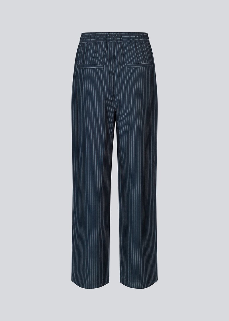Habitbukser i mørkeblå med mellemhøj talje, læg og lange, vide ben. IsabelMD pants har gylp med lynlås og knap, sidelommer og paspolerede baglommer.
