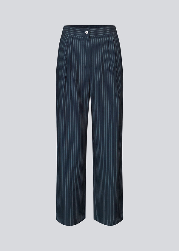 Habitbukser i mørkeblå med mellemhøj talje, læg og lange, vide ben. IsabelMD pants har gylp med lynlås og knap, sidelommer og paspolerede baglommer.