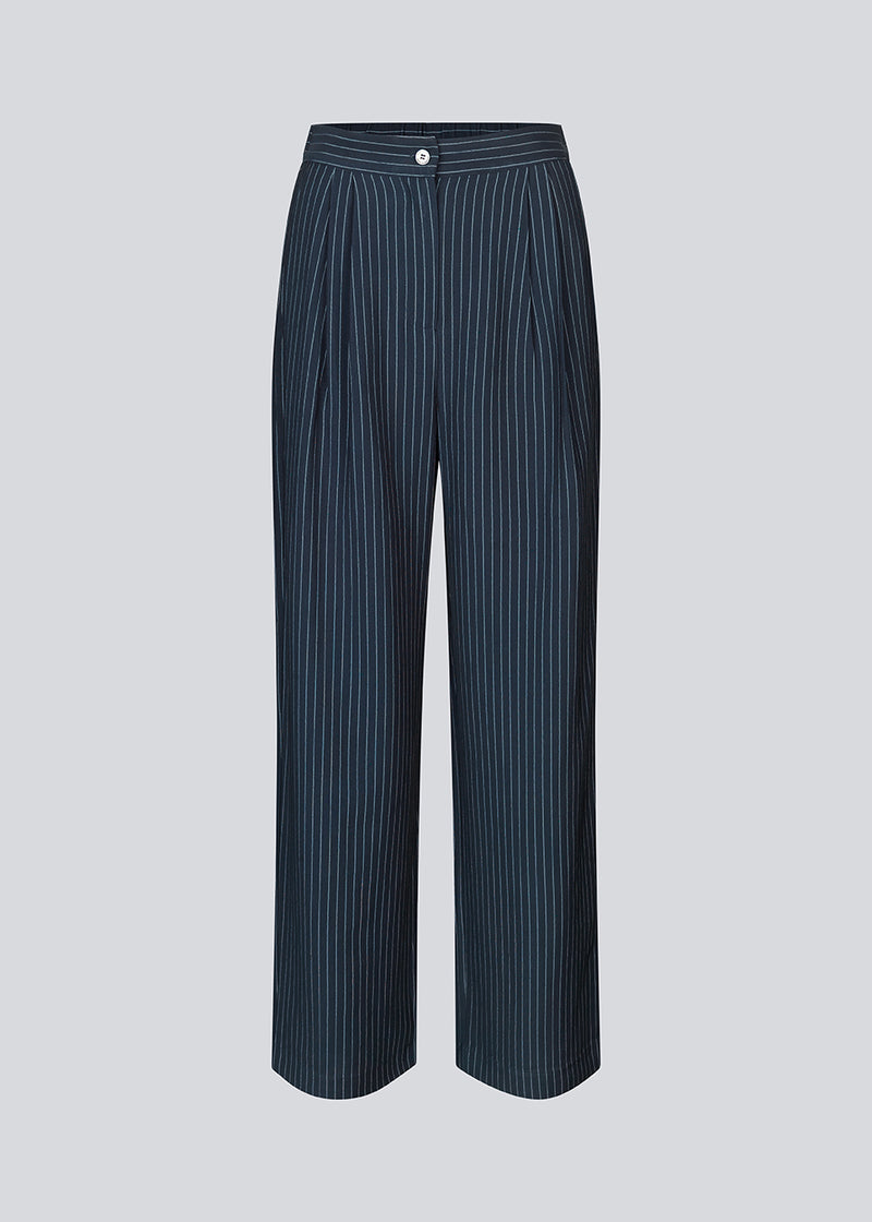 Habitbukser i mørkeblå med mellemhøj talje, læg og lange, vide ben. IsabelMD pants har gylp med lynlås og knap, sidelommer og paspolerede baglommer.