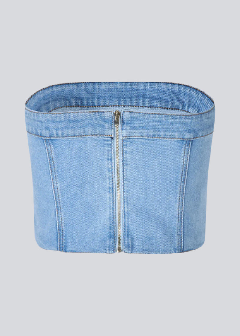 Kort denim top i corset design. IvannaMD top er fremstillet i lys denim og har en lynlåslukning i ryggen.