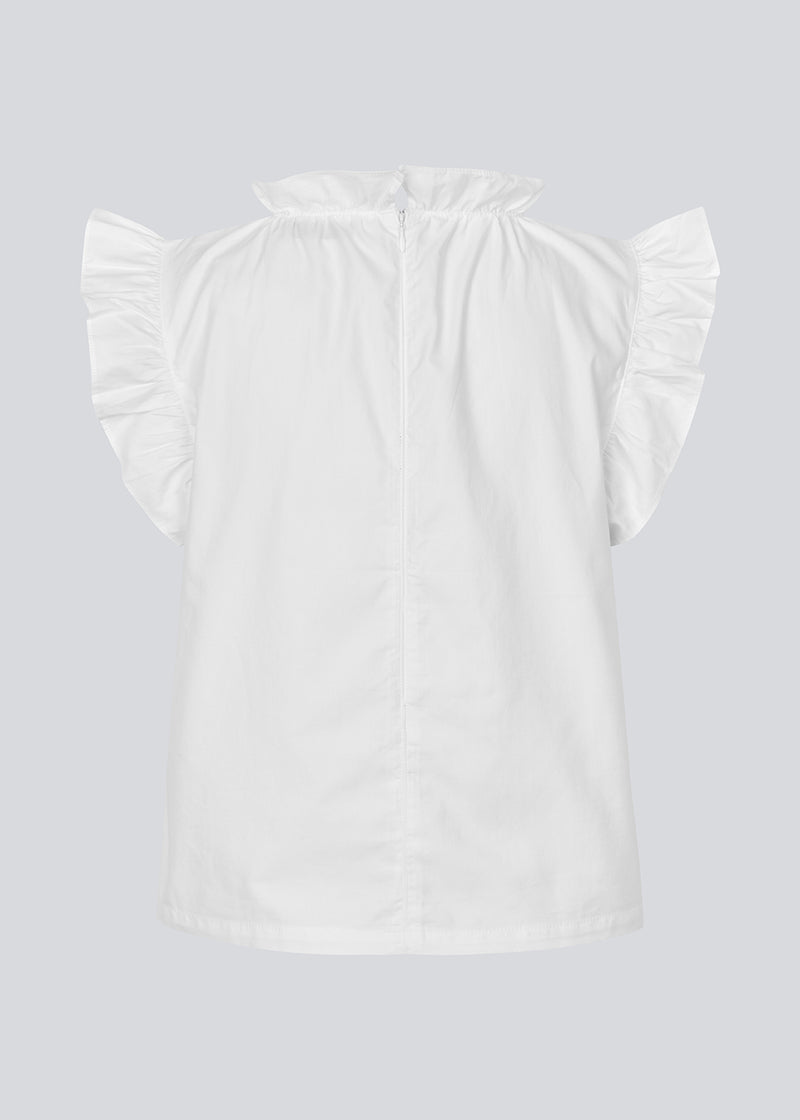 Løs top i hvid med flæsedetaljer ved ærme og hals. IzakMD top er ærmeløs og har en skjult lynlås i ryggen. Modellen er 177 cm og har en størrelse S/36 på.