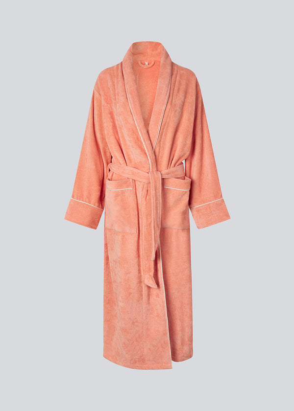 Lyserød oversize badekåbe i 100% økologisk bomuld. Josefinemd bathrobe har store lommer, bindebånd og kontrastkanter, der giver den et elegant touch. Badekåben har et fint og diskret logo på ryggen. Perfekt til hyggelige morgener. Josefine Vogt (165 cm) og modellen (177 cm) har begge størrelse Small på.